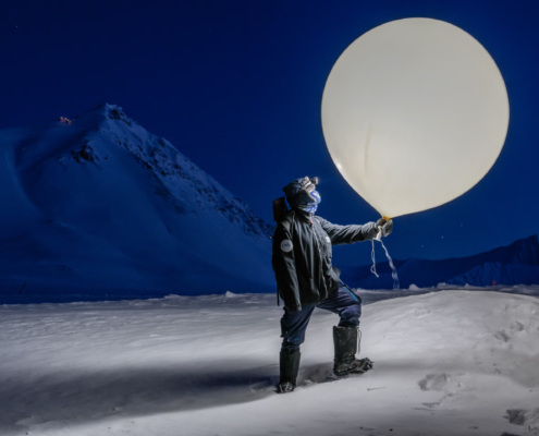 Znanstveniki zbirajo podatke s polarnih območij, da bi razumeli, kako se svet spreminja. Vremenski balon, ki ga drži Hauptova, po navadi nosi radijsko sondo, instrument, ki meri temperaturo, vlažnost in tlak.