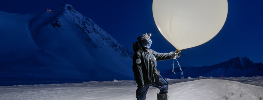 Znanstveniki zbirajo podatke s polarnih območij, da bi razumeli, kako se svet spreminja. Vremenski balon, ki ga drži Hauptova, po navadi nosi radijsko sondo, instrument, ki meri temperaturo, vlažnost in tlak.